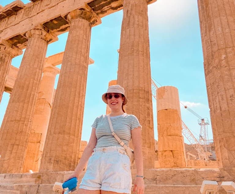 person holding a camera by the parthenon in athens